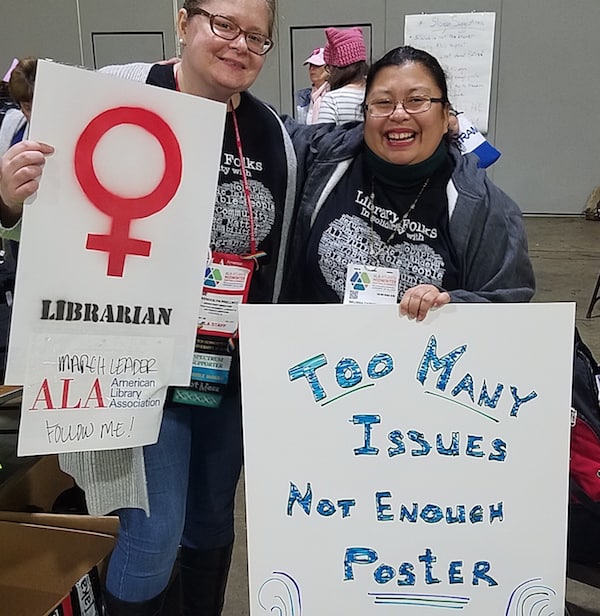 Wendy Prellwitz, left, of ALA’s Office for Diversity, Literacy, and Outreach Services, helped Midwinter attendees make posters for the march. Photo: George M. Eberhart/American Libraries