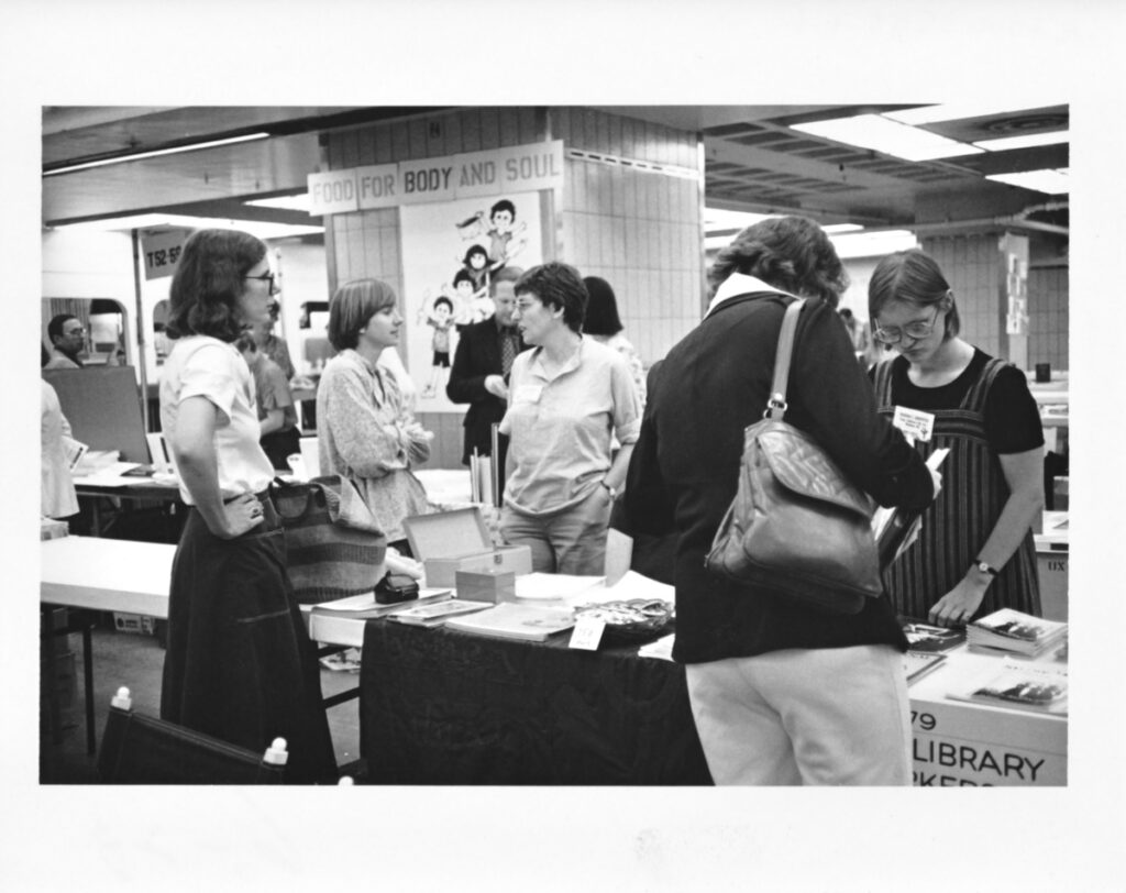 Conference attendees at the COSWL exhibit tables at the 1980 Annual Conference in New York
